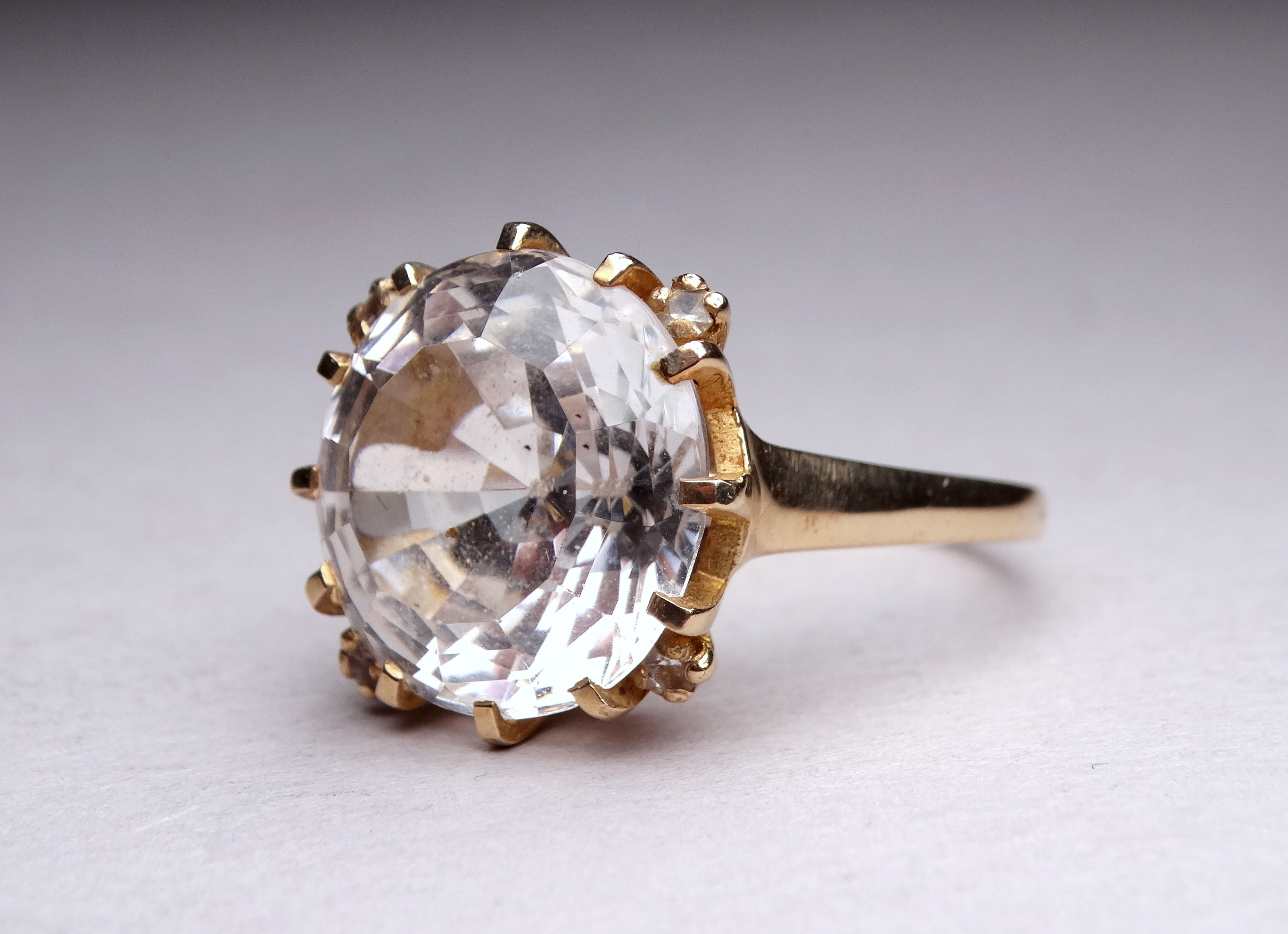 A 9ct yellow gold gem set ring - the large white stone possibly topaz, within a claw setting, ring