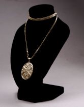 A 9ct yellow gold locket and chain - the oval locket with a foliate engraved cover, on a fine curb-