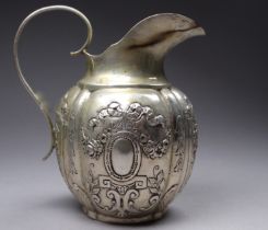 A late 19th century continental white metal cream jug - of gourd form and decorated with floral