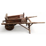 A late 19th century oriental elm wheelbarrow - length 58cm.