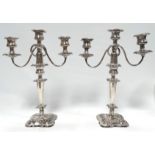 A pair of silver plated candlesticks - three branch with wrythen arms and square shaped bases,