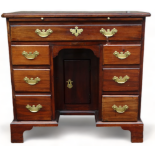 An early George III mahogany kneehole desk - the rectangular top with re-entrant corners above a