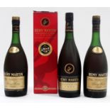 A bottle of Remy Martin cognac - boxed, together with two further un-boxed examples. (3)