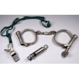 A pair of early 20th century Hiatt handcuffs - with key, together with a War Department whistle