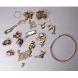 A quantity of 9ct gold charms - a variety of shapes, together with a 9ct gold child's bangle,
