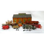 A Hornby 0 gauge clockwork tank engine - in green livery with rolling stock in a distressed box,