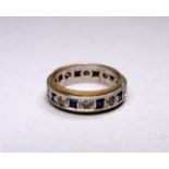 A sapphire and white stone eternity ring - set in 9ct yellow and white gold, size K, weight 3.7g.