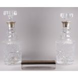 A pair of silver mounted cut glass decanters - London 1974, of circular mallet form, height 28cm,