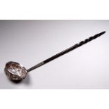 An 18th/19th century silver toddy ladle - the bowl set with a shilling and fitted with a contorted