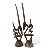 A pair of African carved hardwood and metal mounted figures of gazelles - each with a further