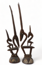 A pair of African carved hardwood and metal mounted figures of gazelles - each with a further