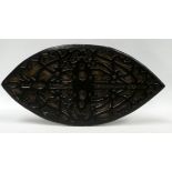 A carved wooden shield - with strapwork decoration, 69 x 34cm.