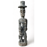 A late 19th century African hardwood carved figure of a chieftain - wearing a top hat and holding