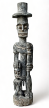 A late 19th century African hardwood carved figure of a chieftain - wearing a top hat and holding