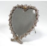 An early 20th century silver plated easel mirror - heart shaped with a bevel edge, foliate pierced