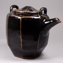 A studio pottery tenmoku glazed teapot - of faceted form, lacking handle, height 15cm.