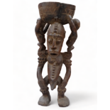 An African carved hardwood bowl - the male figure support with two further figures flanking on his
