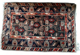 A 20th century Kazak style rug - with stylised trees and bushes on a brown ground, within a multi