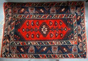 A 20th century Kazak style rug - with a tree pattern on a madder ground within a multi stripe