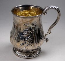 A Victorian silver baluster shaped mug - indistinct marks, repousse decorated with flowers and