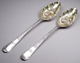 A pair of silver George III and later berry spoons - London 1792 & 1805, with bright cut handles and