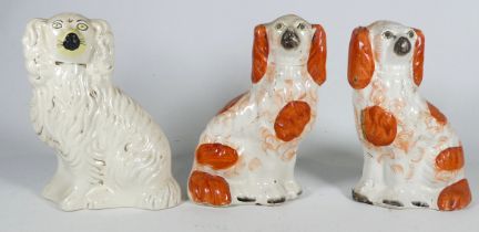 A pair of 19th century Staffordshire spaniels - height 19cm, together with another spaniel.