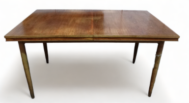 A post war teak extending dining table - the rectangular top opening to reveal three hinged leaf