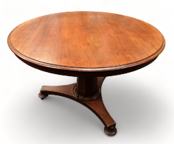 A Victorian mahogany circular table - the hinged top on a tapering octagonal support and tripod