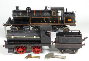 An 0 gauge clockwork locomotive L&NWR in black livery - together with another smaller locomotive.