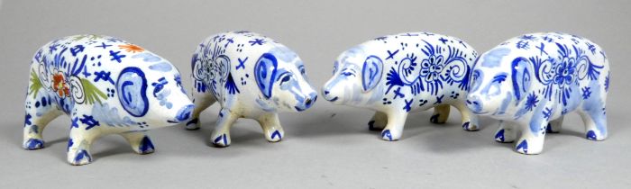A Delft pottery pig - polychrome painted with stylised flowers, 11cm wide, together with three other