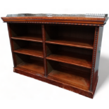 An early Victorian walnut open bookcase - the rectangular top with three quarter gallery above