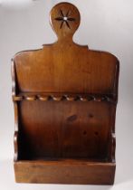 An early 20th century stained pine pipe rack - width 25cm, depth 10cm, height 42cm.
