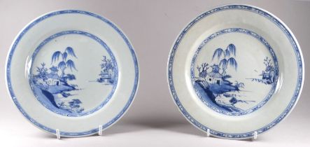 A pair of late 19th century Chinese blue and white plates - decorated with a building on an