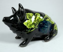 Wemyss Griselda Hill pottery pig - seated, black and decorated with grape and vine, 18cm wide