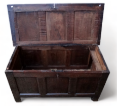 An early 18th century oak coffer - the three panel lid enclosing an interior with a candle box above