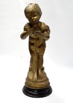 A cast figure of a cherub - gilt painted and raised on a circular base, height 60cm.