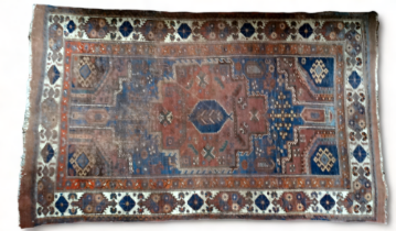 An early 20th century Qashqai rug - with serrated gul on a madder ground with a blue garden and