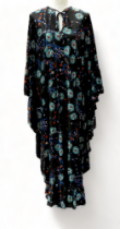 An English Lady full length dress - floral on a black ground with frilled batwing sleeves,