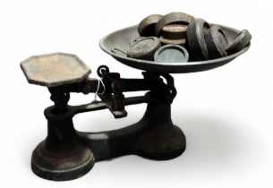 A pair of early 20th century cast iron balance scales - with various associated weights.