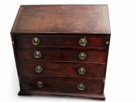 A George III mahogany bureau - the cleated fall enclosing drawers and pigeon holes about a central
