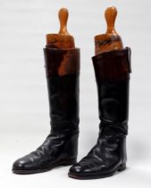 A pair of vintage black and mahogany topped leather riding boots - together with original wooden boo