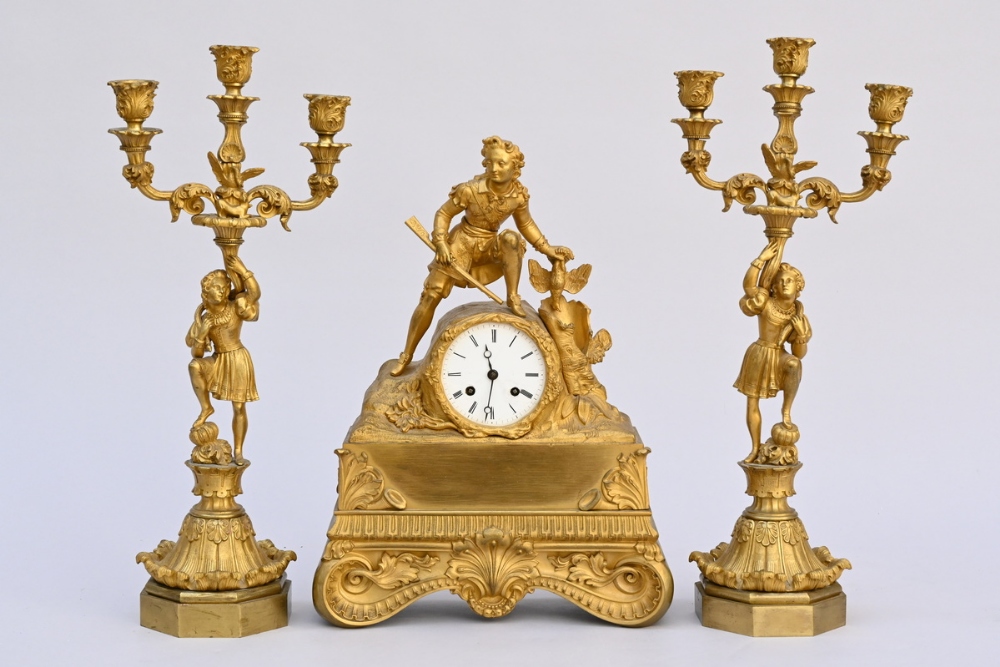 Three piece clockset in gilt bronze 'hunter' (clock 40x29x10cm) (candlesticks h48cm)