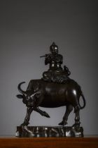 A Chinese bronze sculpture 'flute player on a waterbuffalo', Qing dynasty (29x21x14cm)