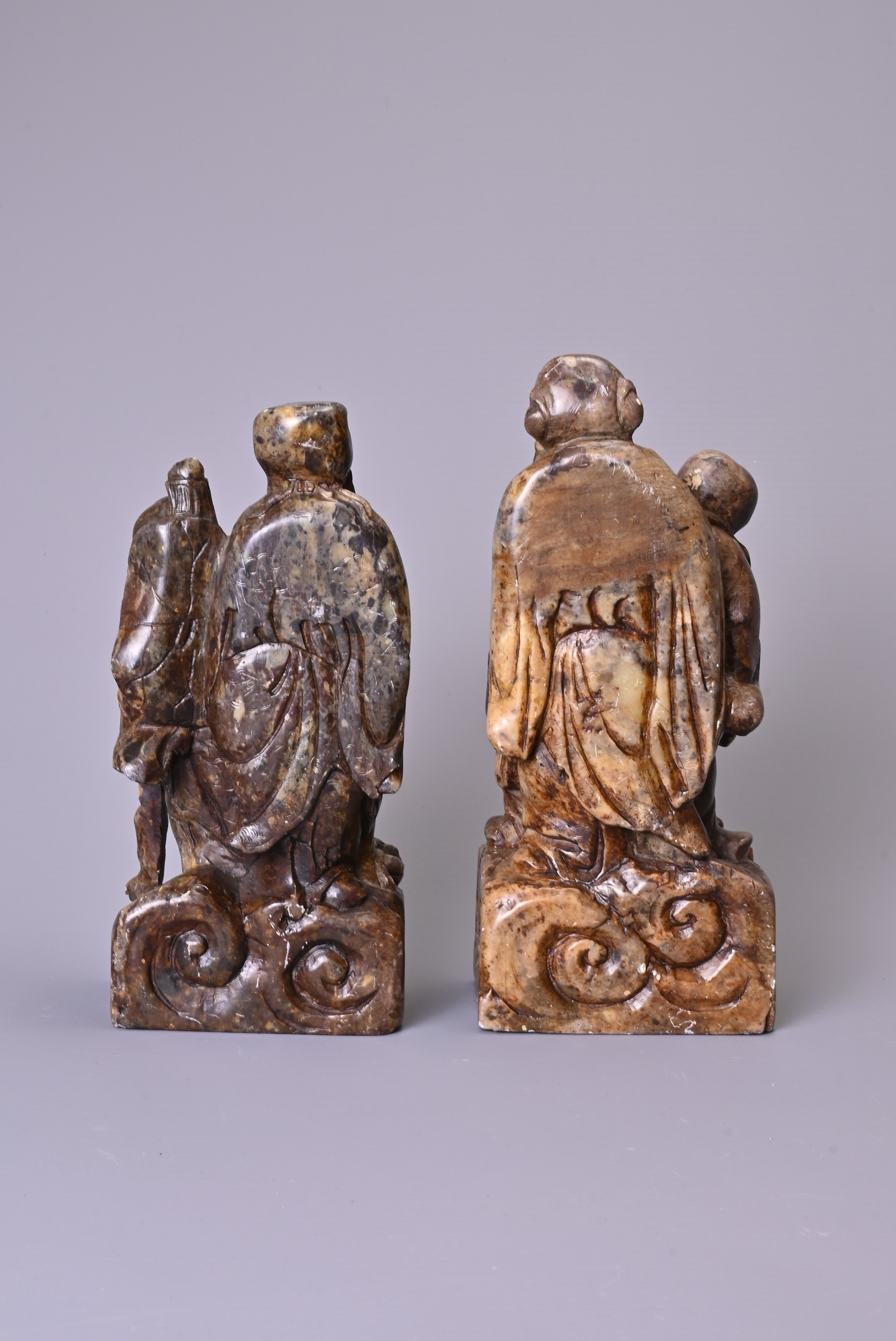 A PAIR OF 20TH CENTURY CARVED SOAPSTONE FIGURES OF A SAGE AND ATTENDANT. Each in mottled dark - Image 3 of 7