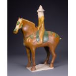 A CHINESE SANCAI GLAZED POTTERY MODEL OF A HORSE AND RIDER, TL TESTED, TANG DYNASTY (AD 618-907).