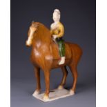 A CHINESE SANCAI GLAZED POTTERY MODEL OF A HORSE AND RIDER, TL TESTED, TANG DYNASTY (AD 618-907).