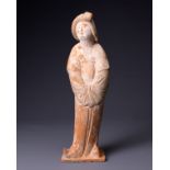 A CHINESE POTTERY FIGURE OF A COURT LADY, TANG DYNASTY (AD 618-907). Modelled wearing long flowing