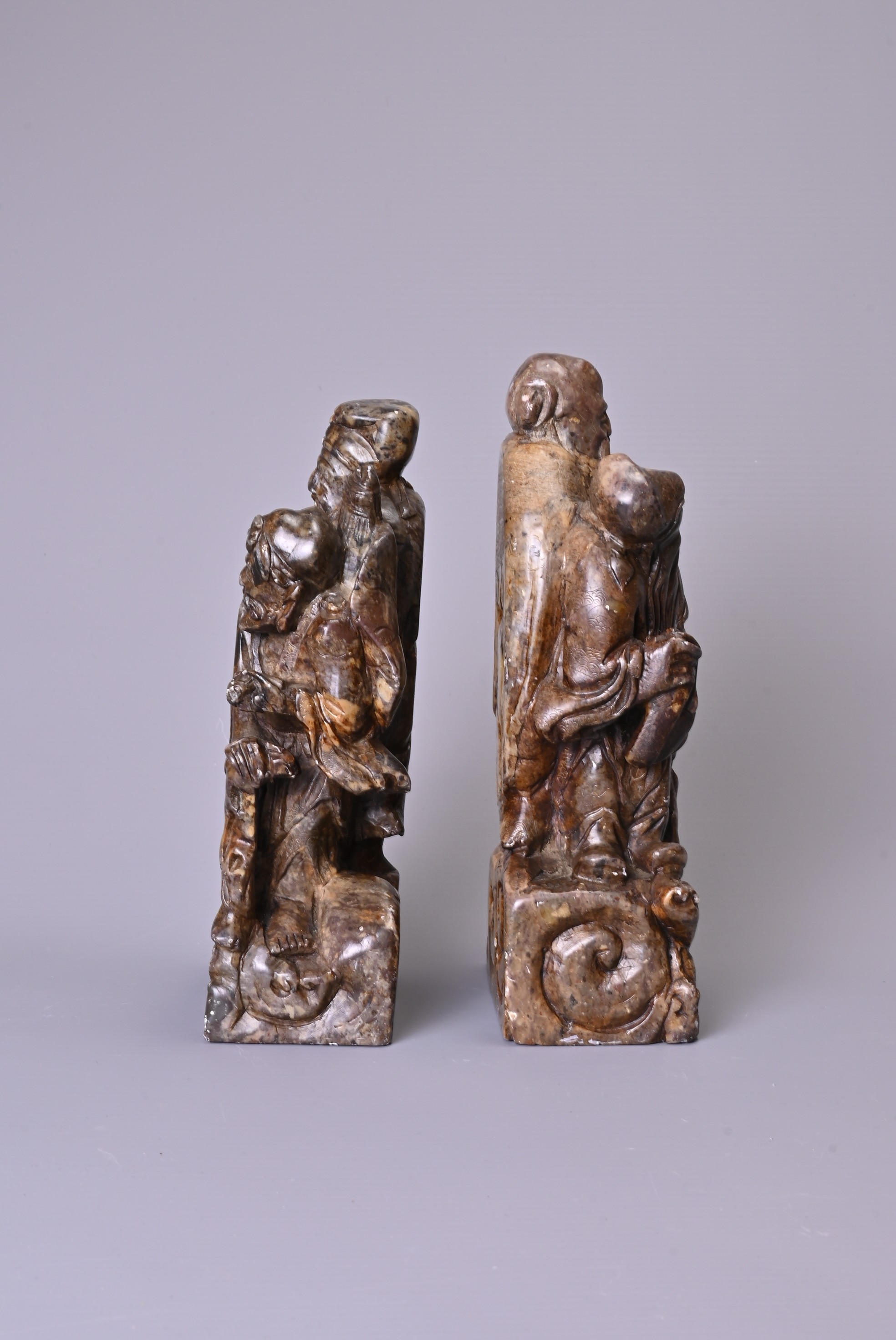 A PAIR OF 20TH CENTURY CARVED SOAPSTONE FIGURES OF A SAGE AND ATTENDANT. Each in mottled dark - Image 4 of 7