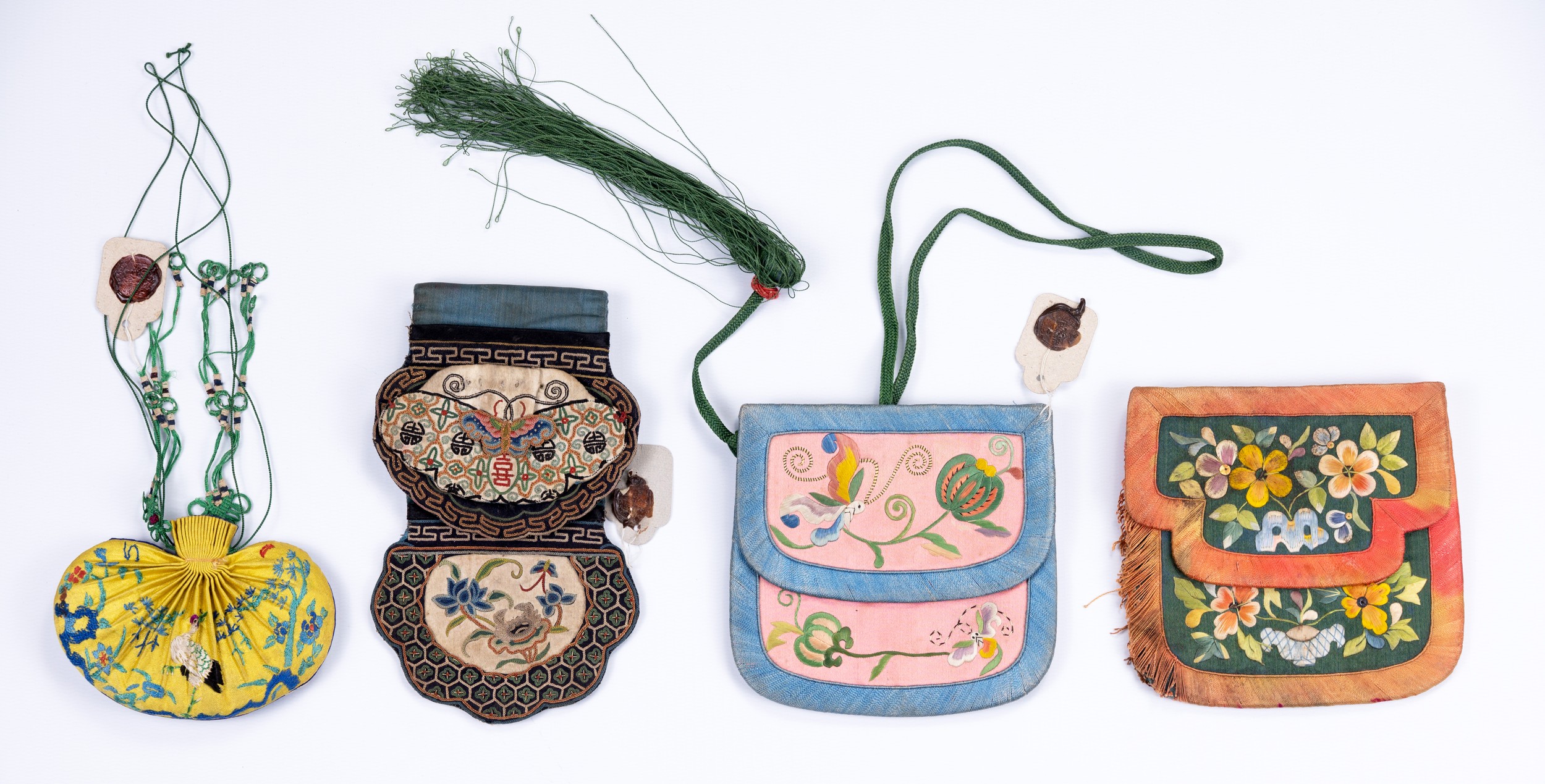 FOUR CHINESE EMBROIDERED SILK PURSES, LATE QING/EARLY 20TH CENTURY. Comprising: a ruyi-shaped blue