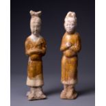 TWO CHINESE STRAW GLAZED POTTERY FIGURES OF ATTENDANTS, TANG DYNASTY (AD 618-907). The male and